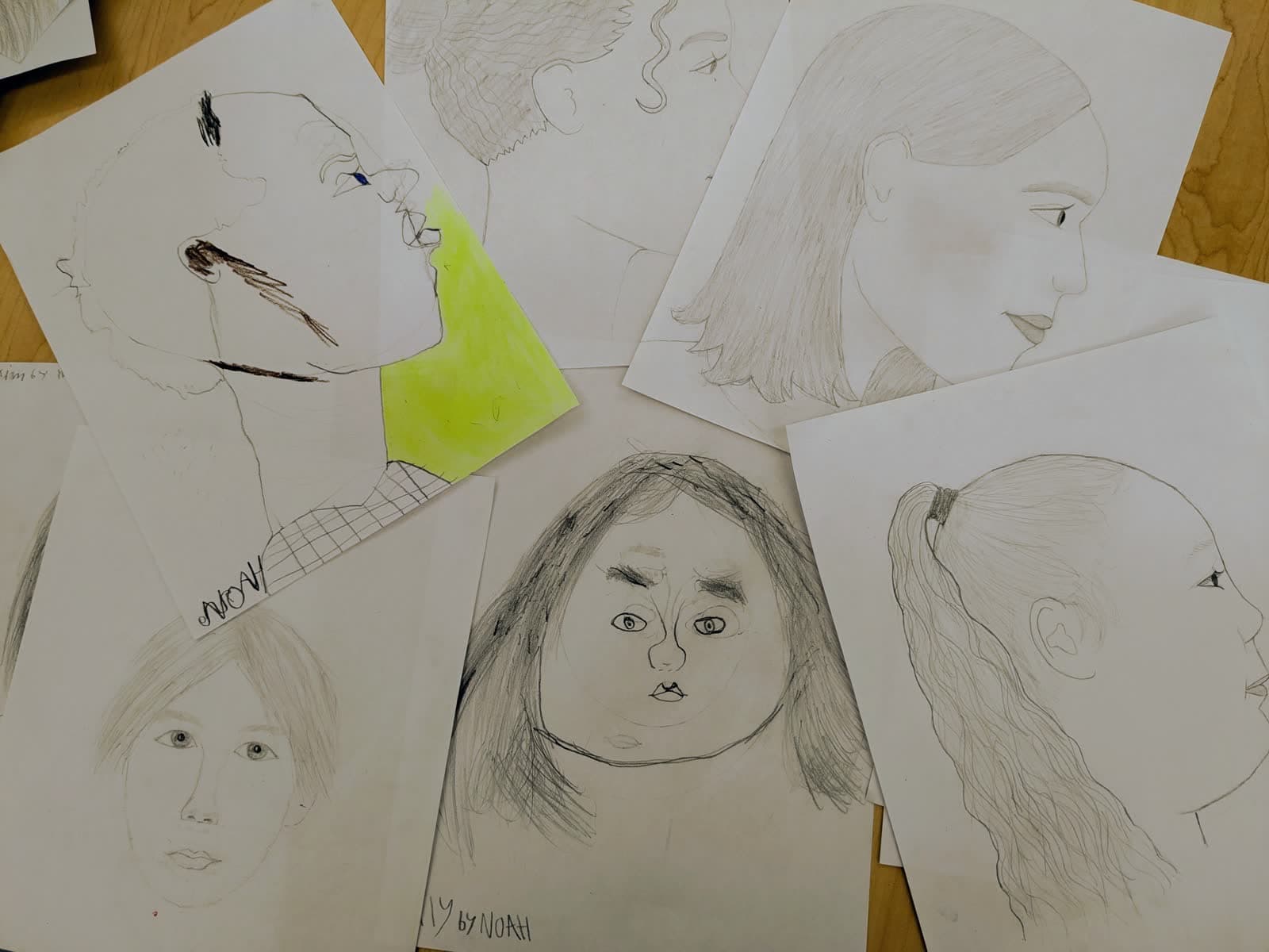 Student portrait drawings laid out on a table