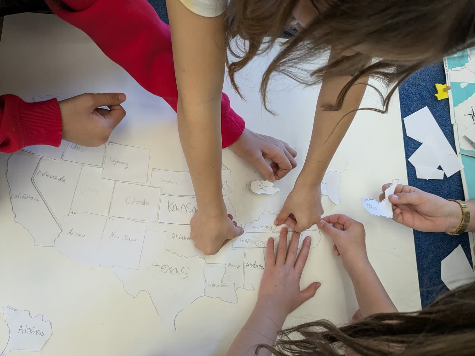 Students working together on a large floor map of the United States